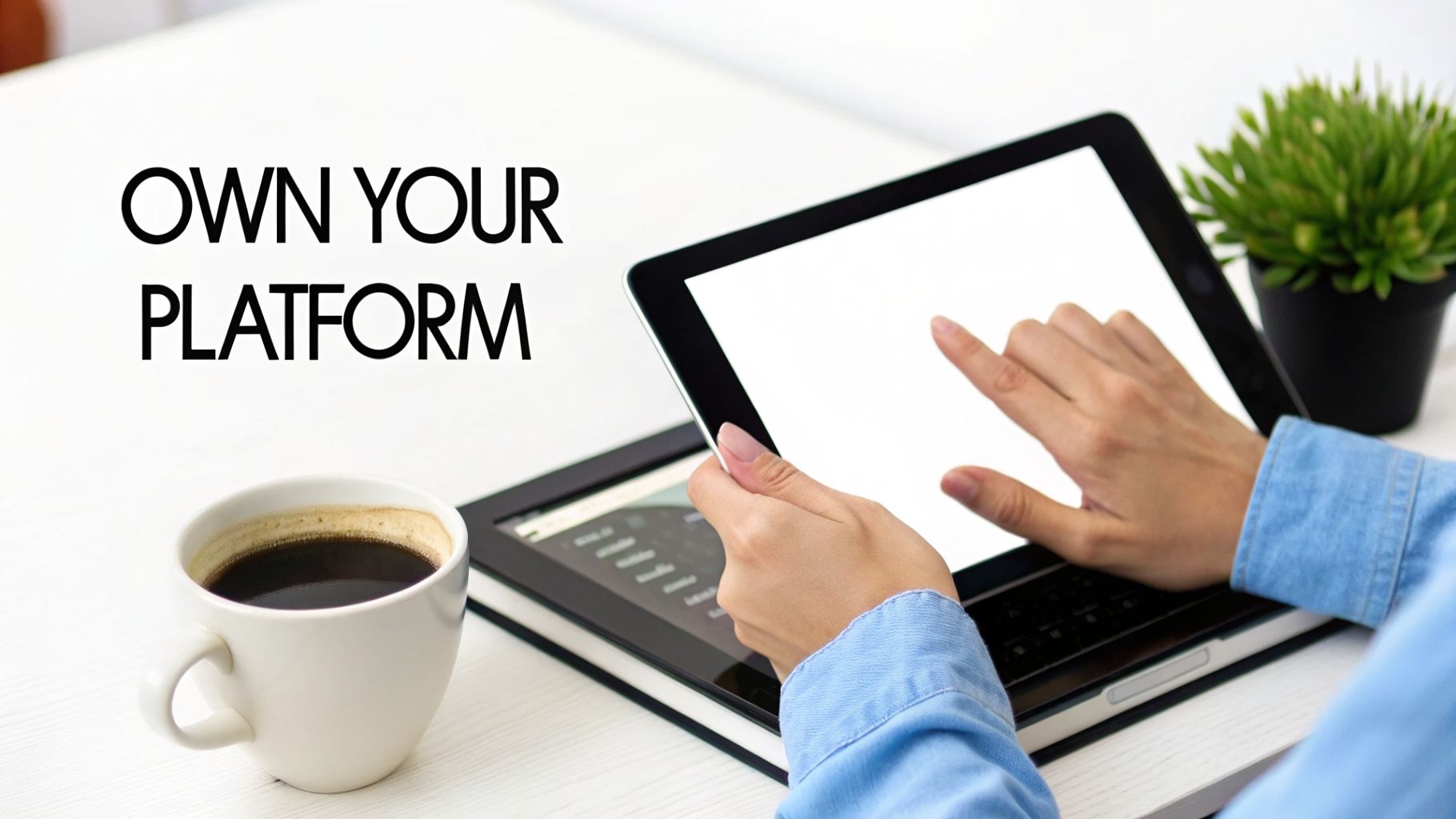 A person's hands interact with a tablet on a desk, next to a coffee cup and the text 'OWN YOUR PLATFORM'.